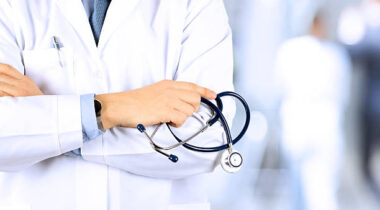 Portrait an unknown male doctor holding a stethoscope behind